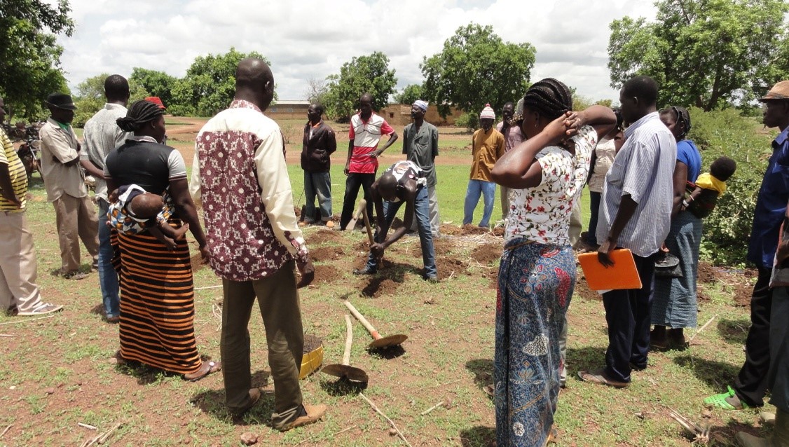 Community members gather to see a demonstration of zai – water pits that retain water during the raining season- close to Ouahigouya, Burkina Faso